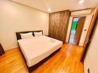 a bedroom with a white bed with a wooden floor at VortexLuxApartman KLCC, kuala lampur city in Kuala Lumpur
