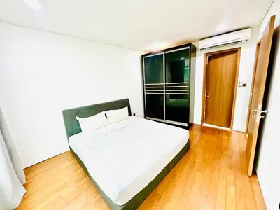 a bedroom with a white bed and a wooden floor at VortexLuxApartman KLCC, kuala lampur city in Kuala Lumpur
