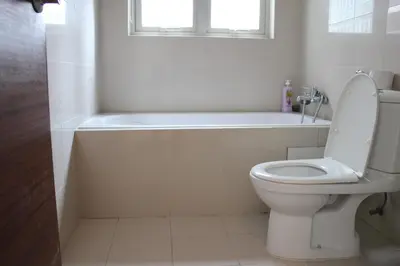 a bathroom with a toilet and a tub and a window at Central 2BR Apt 5 mins to KLCC Twin Towers in Kuala Lumpur
