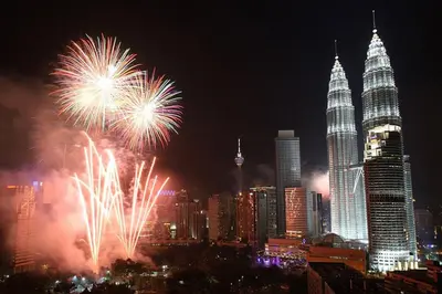 a fireworks display in a city with the petronas towers at Central 2BR Apt 5 mins to KLCC Twin Towers in Kuala Lumpur