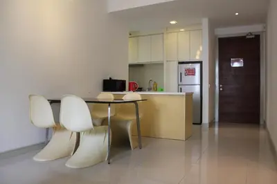 a kitchen with a table and chairs and a refrigerator at Central 2BR Apt 5 mins to KLCC Twin Towers in Kuala Lumpur