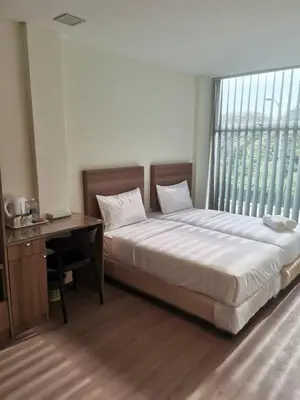 a bedroom with a bed and a desk and a window at SCC Velodrome KL in Kuala Lumpur