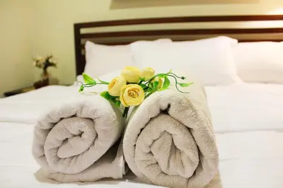 a couple of towels sitting on a bed at D'CASA Fairlane 