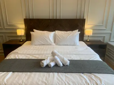 a teddy bear is laying on a bed at Ceylonz Suites by ROOMY in Kuala Lumpur