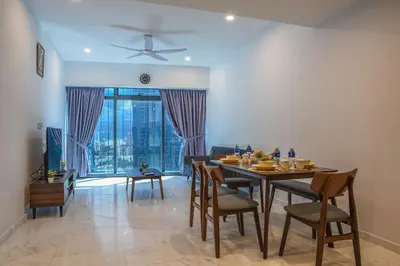 a dining room with a table and chairs and a large window at Eaton KLCC Suites By Elite in Kuala Lumpur