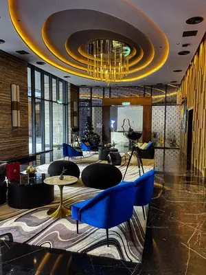 a lobby with blue chairs and a chandelier at STAR RESIDENCE KLCC in Kuala Lumpur