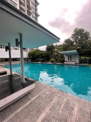 a large blue swimming pool next to a building at Blue Sky Apartment in Kuala Lumpur