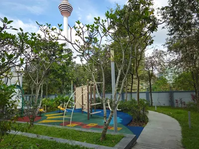 a playground with a slide in a park with a tower at Blue Sky Apartment in Kuala Lumpur