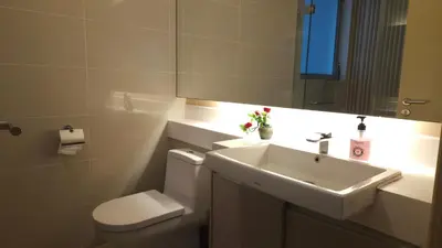 a bathroom with a sink and a toilet and a mirror at Blue Sky Apartment in Kuala Lumpur