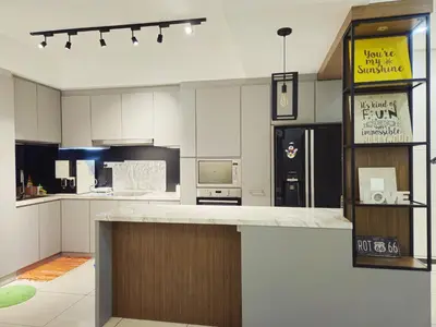 a large kitchen with a counter and a refrigerator at Blue Sky Apartment in Kuala Lumpur