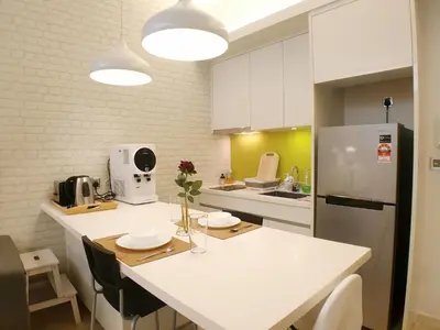 a kitchen with a white counter and a refrigerator at The Signature & Hotel Suites Mont Kiara Kuala Lumpur in Kuala Lumpur