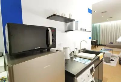 a kitchen with a tv on top of a refrigerator at The Blueprint @ Bangsar South Mid Valley in Kuala Lumpur