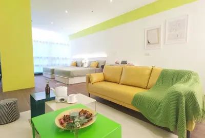 a living room with a yellow couch and a table at The Territory @ Bangsar South Mid Valley in Kuala Lumpur