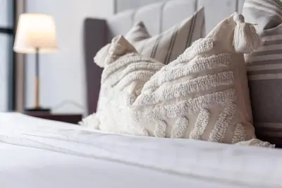 a pile of white pillows sitting on a bed at Scarletz Suites KLCC in Kuala Lumpur