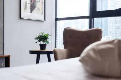 a chair and a table with a plant in a room at Scarletz Suites KLCC in Kuala Lumpur