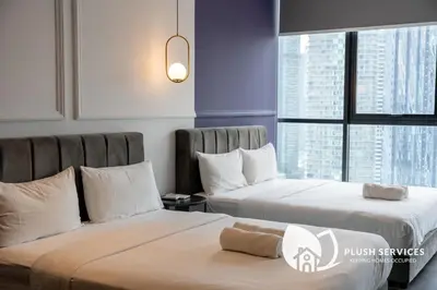 a hotel room with two beds and a window at Scarletz Suites KLCC in Kuala Lumpur