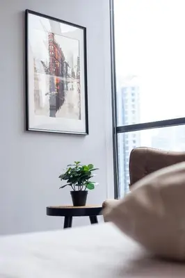 a plant on a table in a room with a picture at Scarletz Suites KLCC in Kuala Lumpur