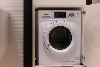 a white washing machine sitting in a room at Banyan Signatures Pavilion Kuala Lumpur in Kuala Lumpur