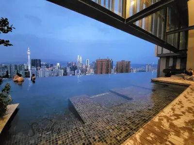 a swimming pool with a city skyline in the background at Lucentia Residence World Class Facilities Apartment Infinity Pool Stunning View in Kuala Lumpur
