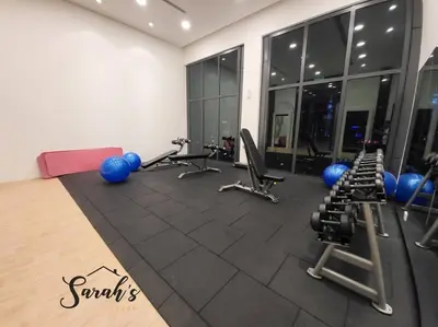 a gym with exercise equipment in a room with windows at Lucentia Residence World Class Facilities Apartment Infinity Pool Stunning View in Kuala Lumpur
