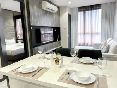 a dining table with plates and wine glasses in a living room at 8 Kia Peng Residence Kuala Lumpur by Scape Stay in Kuala Lumpur