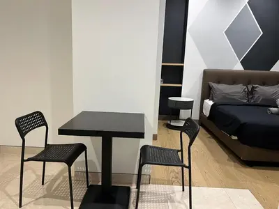a bedroom with a table and chairs and a bed at Lucentia Residence BBCC Lalaport at Kuala Lumpur By Luxe Home in Kuala Lumpur
