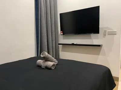 a stuffed animal sitting on a bed with a flat screen tv at Lucentia Residence BBCC Lalaport at Kuala Lumpur By Luxe Home in Kuala Lumpur