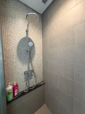 a shower in a bathroom with a tile wall at Lucentia Residence BBCC Lalaport at Kuala Lumpur By Luxe Home in Kuala Lumpur
