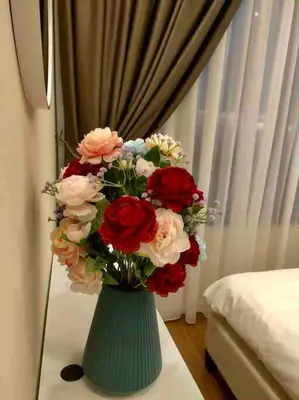 a green vase filled with red and white flowers at Millerz Suite 3R2B Condo Near MidValley 3 Beds 3 Bedrooms Staycation Best Choice in Kuala Lumpur