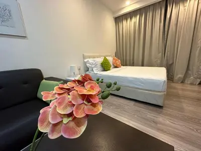 a room with a bed and a couch and a flower at One Bukit Ceylon by Home Suites in Kuala Lumpur