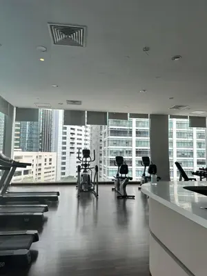 a gym with exercise equipment in a large building at One Bukit Ceylon by Home Suites in Kuala Lumpur