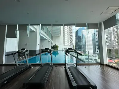 a gym with a swimming pool in a building at One Bukit Ceylon by Home Suites in Kuala Lumpur