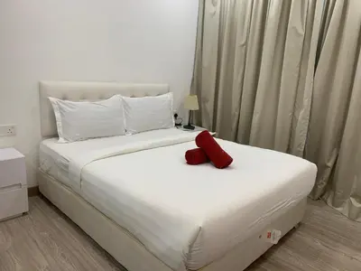 a bedroom with a white bed with a red object on it at RS Suites In Bukit Bintang in Kuala Lumpur