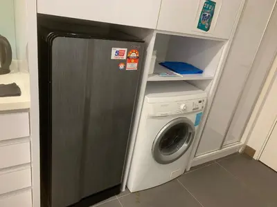 a washer and dryer in a small kitchen at RS Suites In Bukit Bintang in Kuala Lumpur