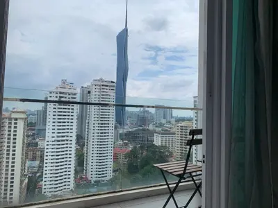 a view of a city from a window with a chair at RS Suites In Bukit Bintang in Kuala Lumpur