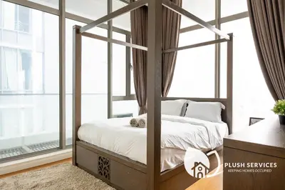 a bedroom with a canopy bed with white sheets at Fairlane Residences by Plush in Kuala Lumpur