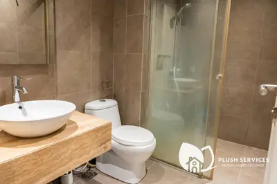 a bathroom with a shower and a toilet and a sink at Fairlane Residences by Plush in Kuala Lumpur