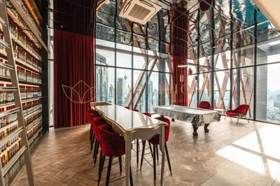 a library with a table and chairs and a piano at Scarletz Premier Suites Kuala Lumpur in Kuala Lumpur