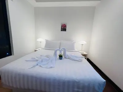 a white bed with two swans sitting on it at CozyHome Suites @ Casa Residency in Kuala Lumpur