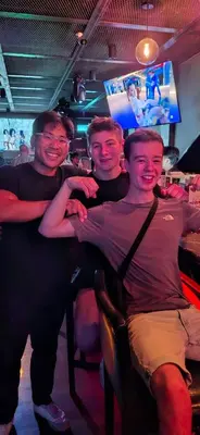 three men sitting in a bar posing for a picture at The Manor by Mingle - Poolside Access Next Door in Kuala Lumpur