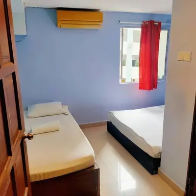 a small room with two beds and a window at RAS International Hotel in Kuala Lumpur