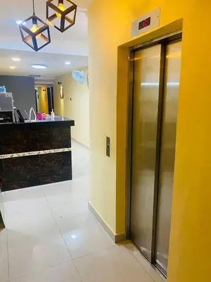 an elevator in a lobby with a yellow wall at RAS International Hotel in Kuala Lumpur