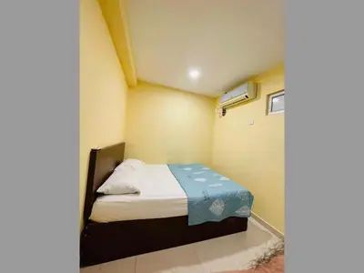 a bedroom with a bed with a blue blanket on it at RAS International Hotel in Kuala Lumpur