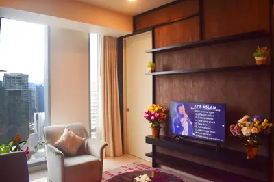 a living room with a chair and a window at Tropicana The Residence KLCC By Rainbow Suites in Kuala Lumpur