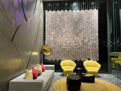 a living room with a couch and two yellow chairs at Tropicana The Residence KLCC By Rainbow Suites in Kuala Lumpur