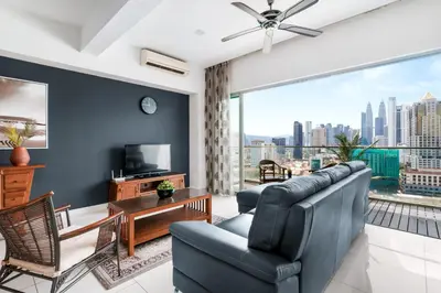 a living room with a couch and a large window at NaiBnB in Regalia Residence in Kuala Lumpur