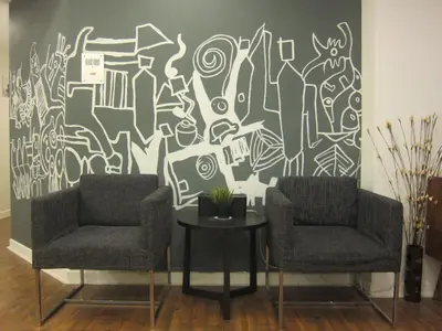 two chairs and a table in front of a mural at Fahrenheit 88 Suites Bukit Bintang H 3R in Kuala Lumpur