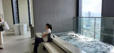a woman sitting in a hot tub in a building at Lucentia Lalaport BBCC, Stuning Infinity Pool in Kuala Lumpur
