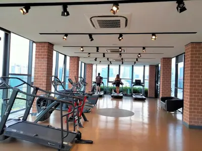 a gym with cardio equipment in a building with windows at Ceylonz Suites Bukit Bintang I HomeBrickz in Kuala Lumpur