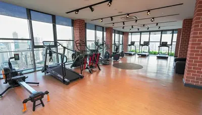 a gym with cardio equipment in a large room with windows at Ceylonz Suites Bukit Bintang I HomeBrickz in Kuala Lumpur